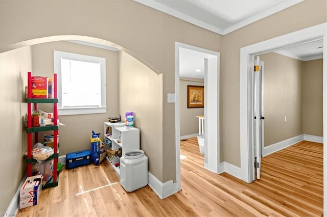 playroom with arched walkways, ornamental molding, wood finished floors, and baseboards