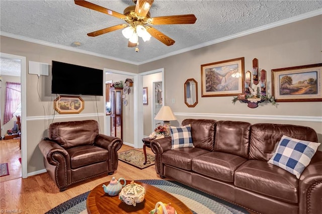 living room featuring ceiling fan, crown molding, a textured ceiling, and light hardwood / wood-style flooring