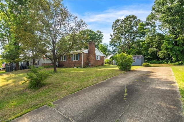 view of front of house with a storage unit and a front yard