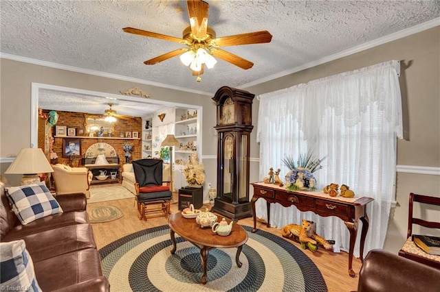 living room with ceiling fan, built in features, crown molding, a textured ceiling, and light wood-type flooring