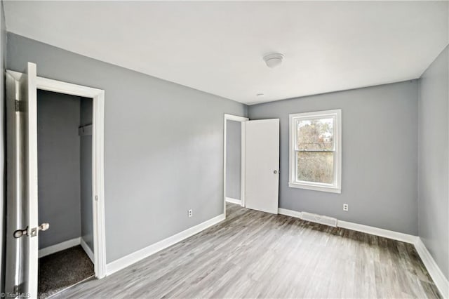 unfurnished bedroom with light hardwood / wood-style flooring and a closet