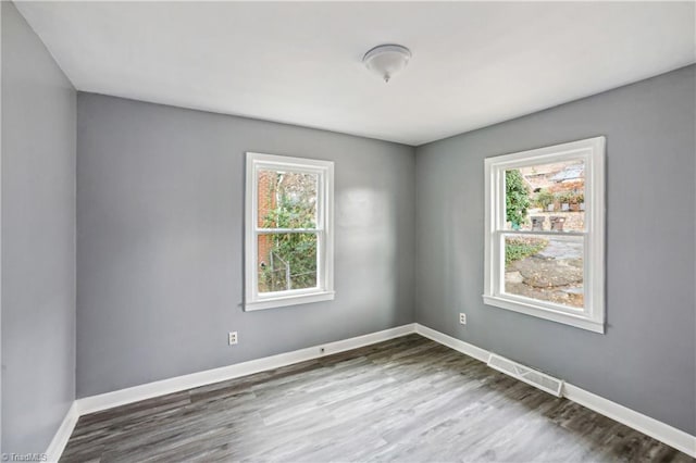 unfurnished room with hardwood / wood-style flooring