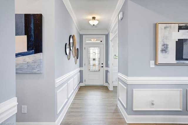 doorway to outside with ornamental molding and light wood-type flooring