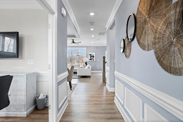 hall with crown molding and light hardwood / wood-style floors