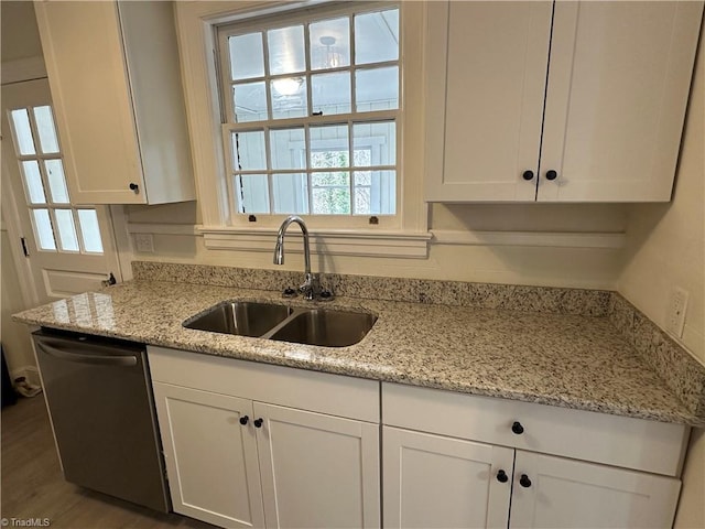 kitchen featuring dishwasher, a sink, white cabinetry, and light stone countertops