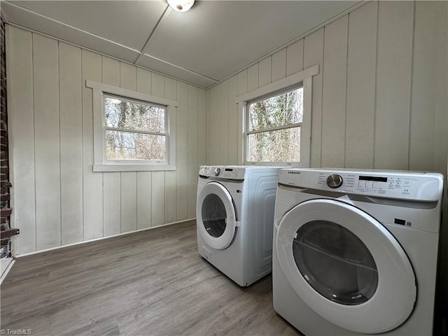 clothes washing area with laundry area, plenty of natural light, light wood-style flooring, and separate washer and dryer