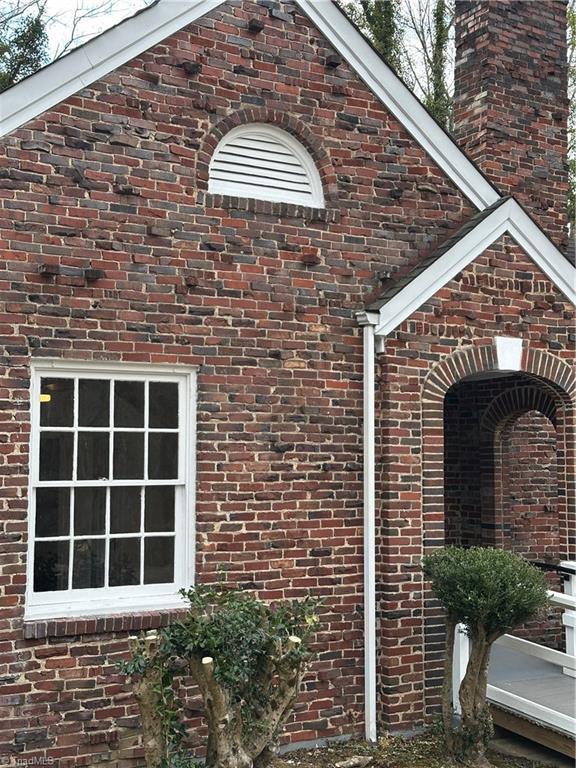 view of side of property with brick siding and a chimney