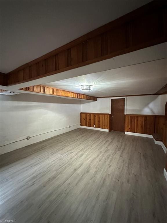 additional living space featuring wood walls, wainscoting, and wood finished floors