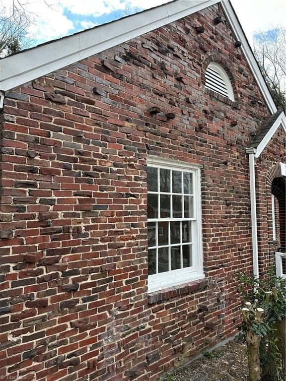 view of side of property featuring brick siding