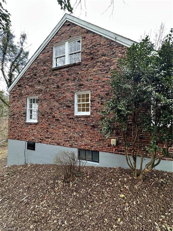 view of side of property featuring brick siding