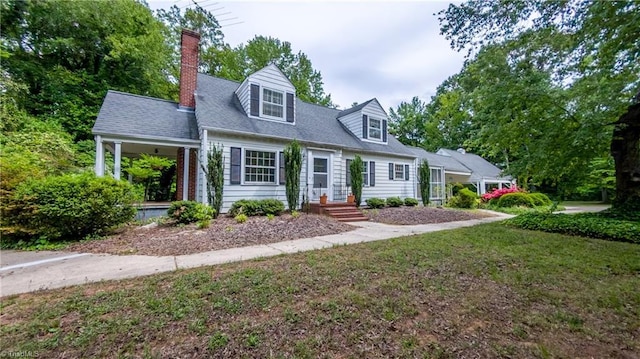 cape cod home with a chimney and a front yard