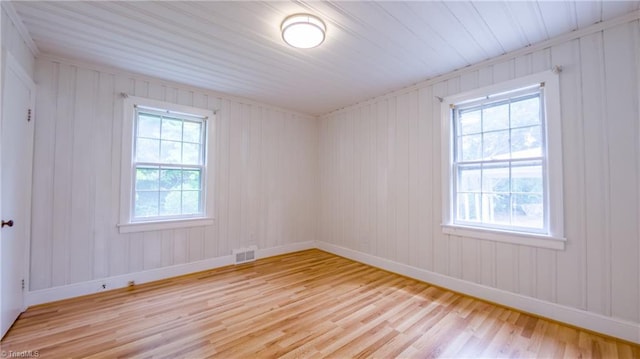 unfurnished room with light wood-type flooring and baseboards