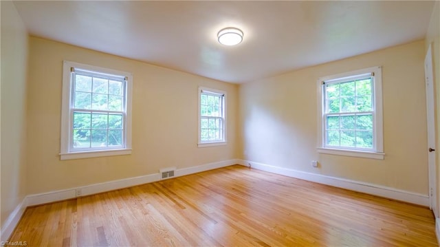 unfurnished room with plenty of natural light, light wood-style floors, and baseboards