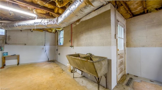 basement with concrete block wall and a sink
