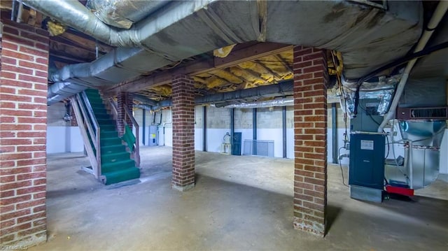 unfinished basement with heating unit, water heater, and stairs