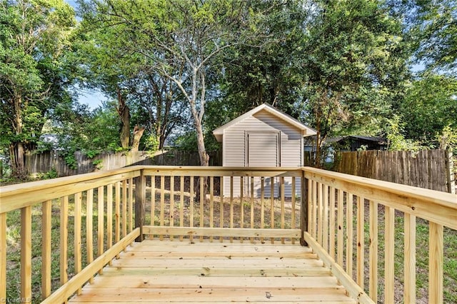 deck with an outbuilding, a storage unit, and a fenced backyard