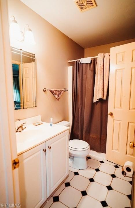 bathroom with toilet, vanity, and curtained shower