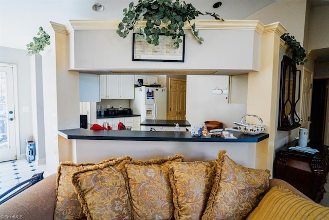 kitchen with white cabinetry and white refrigerator with ice dispenser