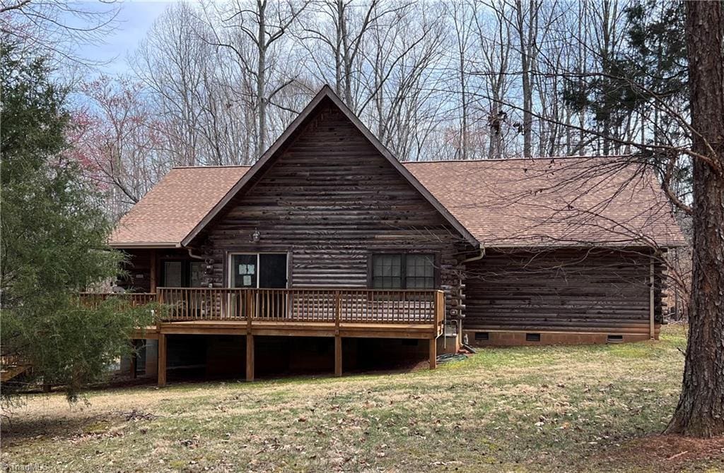 rear view of property with a yard, a wooden deck, a shingled roof, crawl space, and log exterior