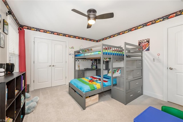 bedroom featuring light carpet, ceiling fan, and a closet