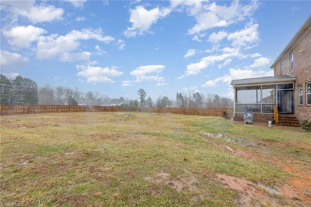 view of yard featuring a sunroom and a rural view