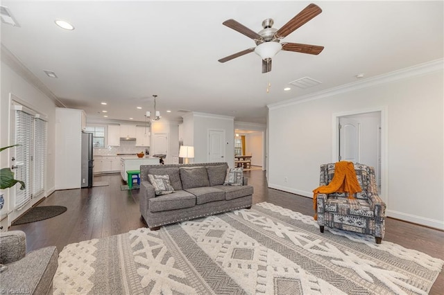 living room with ornamental molding, ceiling fan, and dark hardwood / wood-style flooring