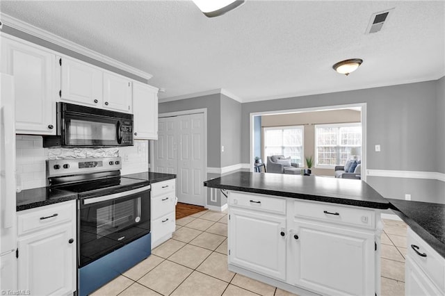 kitchen featuring visible vents, dark countertops, black microwave, and electric stove