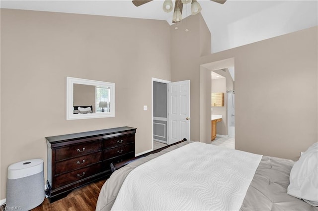 bedroom featuring high vaulted ceiling, ensuite bath, a ceiling fan, and wood finished floors