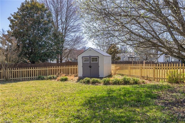 view of yard with a storage unit, a fenced backyard, and an outdoor structure