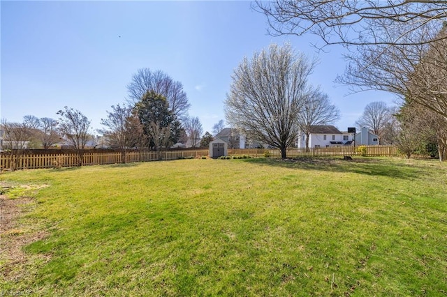 view of yard featuring a storage unit, an outdoor structure, and a fenced backyard