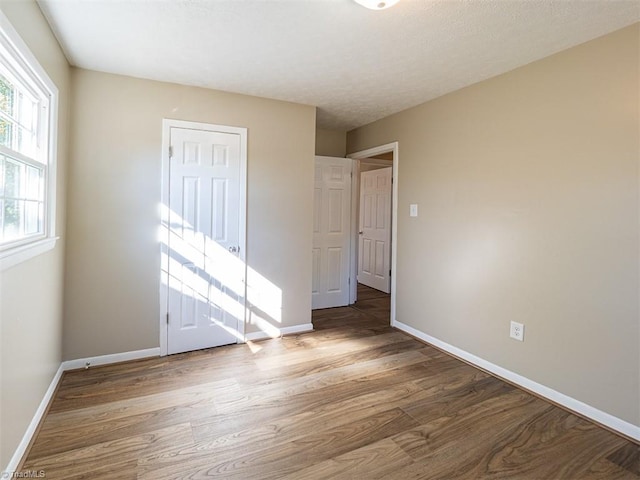 unfurnished bedroom featuring a textured ceiling and hardwood / wood-style flooring