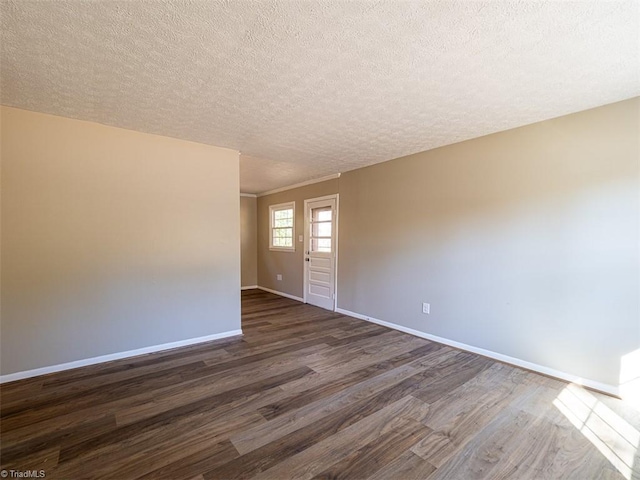 spare room with dark hardwood / wood-style floors and a textured ceiling