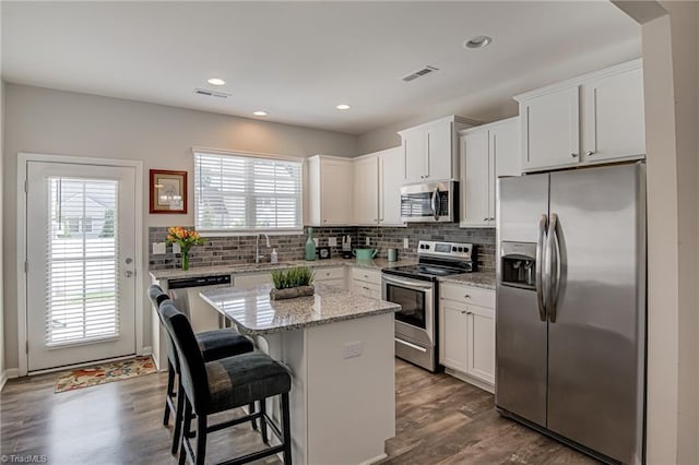 1438 Crestlawn Trl, Pfafftown, NC 27040 - kitchen featuring appliances with stainless steel finishes, a center island, a sink, tasteful backsplash, and recessed lighting