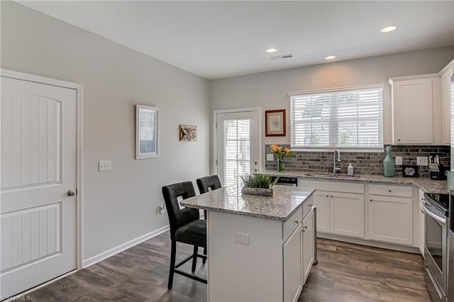 1438 Crestlawn Trl, Pfafftown, NC 27040 - kitchen featuring a sink, electric range, dark wood-type flooring, tasteful backsplash, and a center island