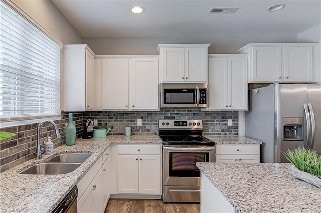 1438 Crestlawn Trl, Pfafftown, NC 27040 - kitchen with stainless steel appliances, a sink, light wood finished floors, white cabinetry, and recessed lighting