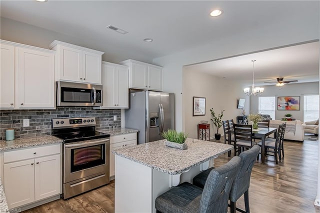 1438 Crestlawn Trl, Pfafftown, NC 27040 - kitchen with stainless steel appliances, decorative backsplash, open floor plan, white cabinetry, and recessed lighting