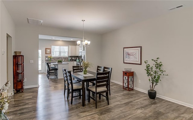 1438 Crestlawn Trl, Pfafftown, NC 27040 - dining area featuring dark wood-type flooring, a chandelier, and baseboards
