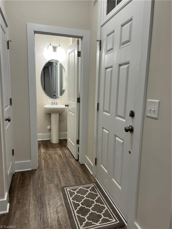 bathroom with wood finished floors, baseboards, and a sink