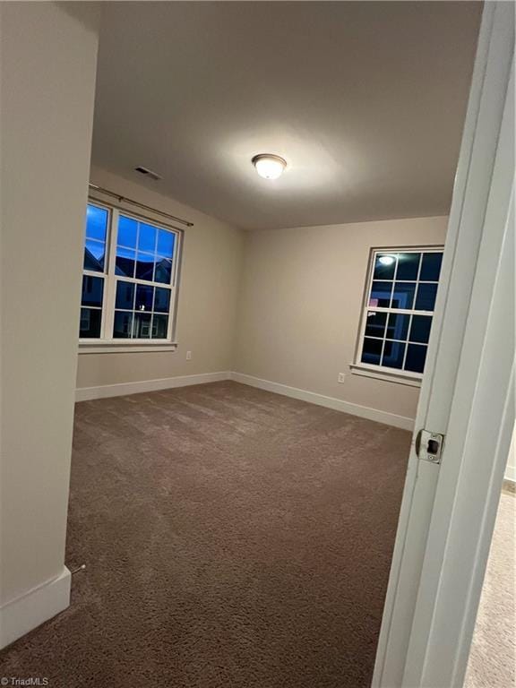 unfurnished room with visible vents, baseboards, and carpet floors