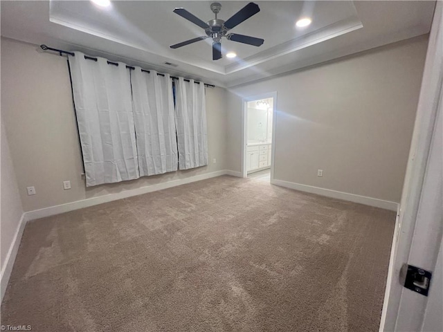 carpeted spare room with recessed lighting, a raised ceiling, baseboards, and ceiling fan