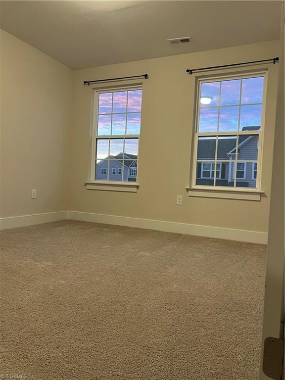 unfurnished room featuring visible vents, baseboards, and carpet floors