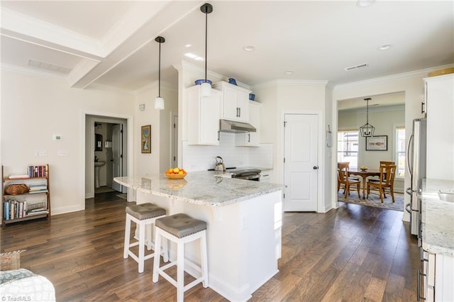 kitchen with light stone counters, white cabinetry, stainless steel appliances, and hanging light fixtures