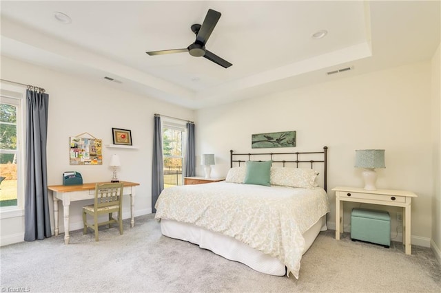 bedroom with ceiling fan, carpet, and a tray ceiling