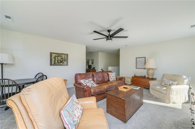 carpeted living room with ceiling fan