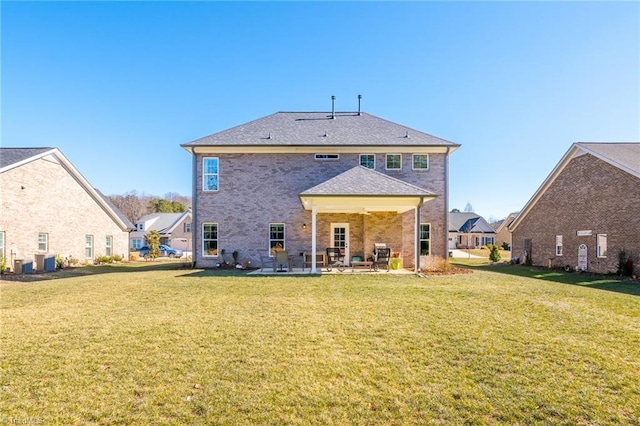 rear view of property featuring a yard, a patio, and central AC unit