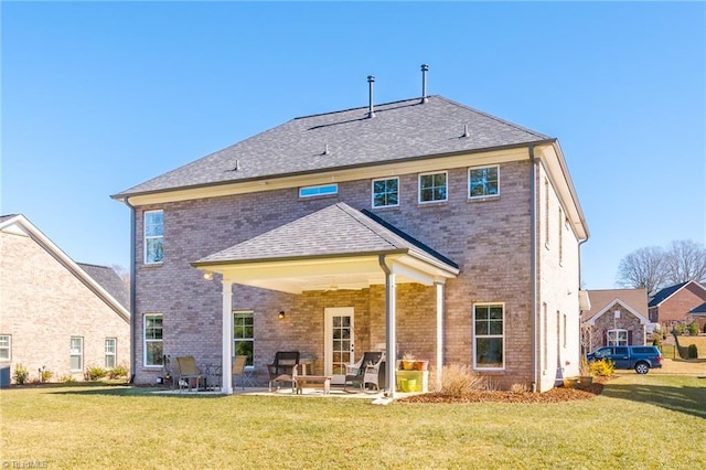 back of property with a lawn and a patio