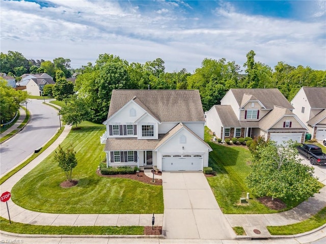 view of front of house with concrete driveway, a front lawn, a residential view, and an attached garage