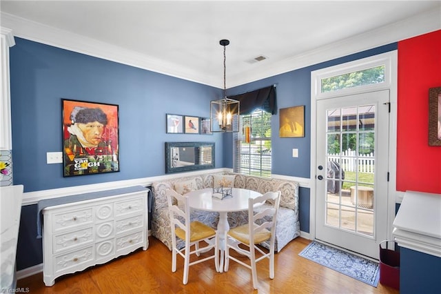 dining area featuring breakfast area, wood finished floors, healthy amount of natural light, ornamental molding, and baseboards