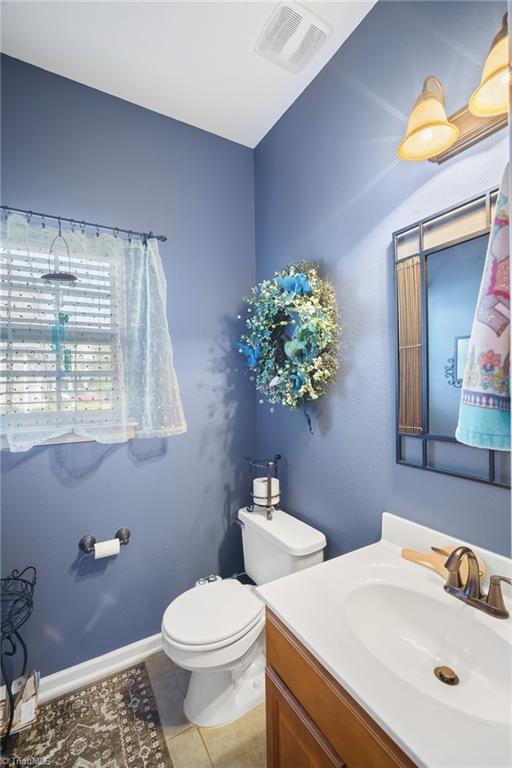 bathroom featuring tile patterned floors, toilet, and vanity