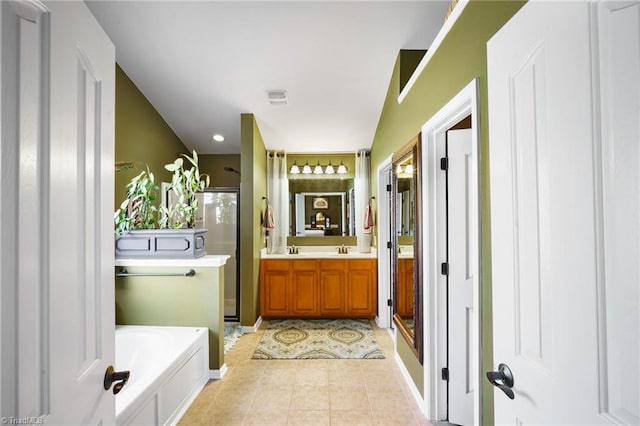 bathroom featuring a stall shower, tile patterned floors, a garden tub, vanity, and baseboards